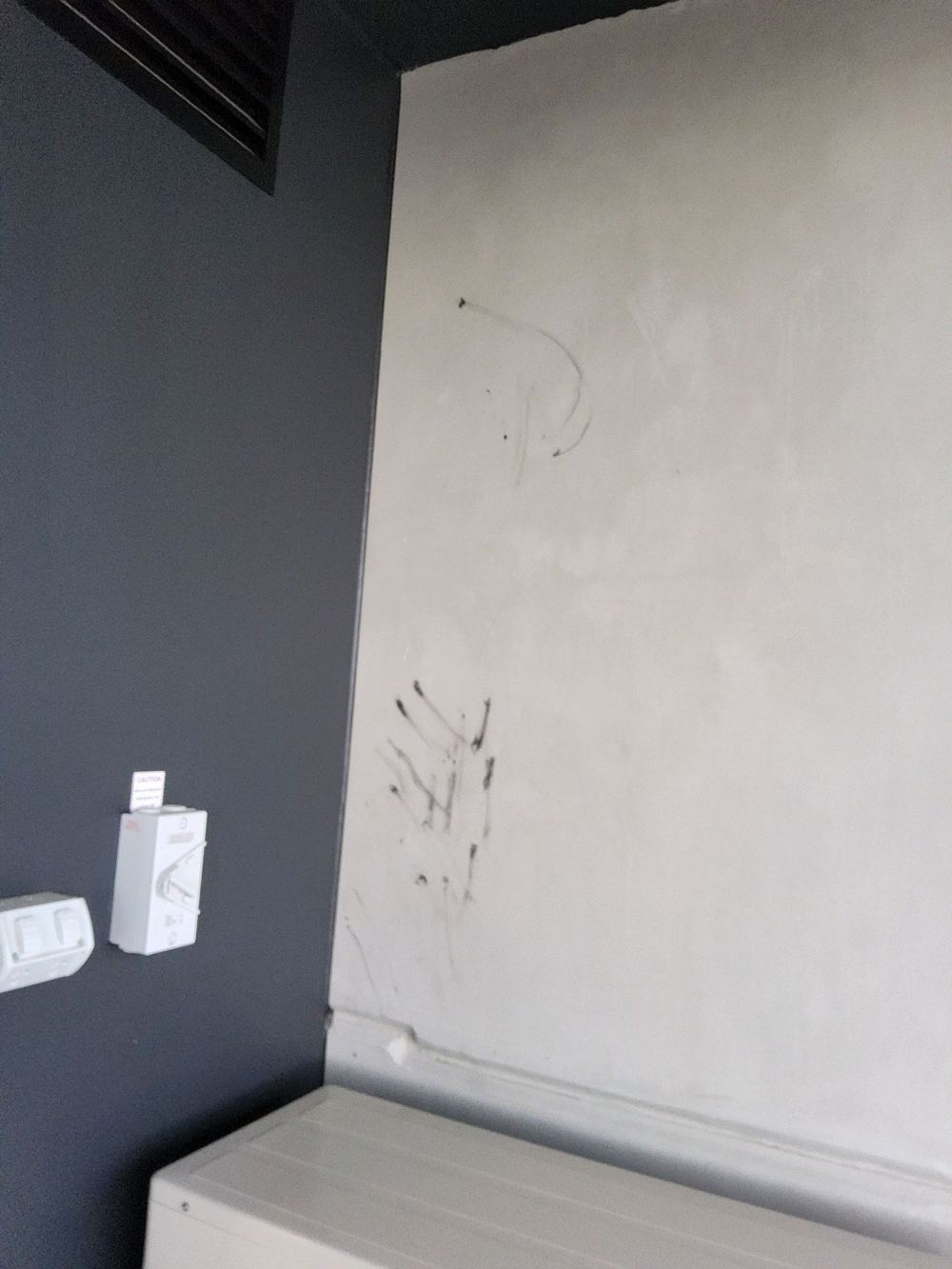 Black caulking smeared across a balcony panel wall, needing a clean before settlement, Castle Hill